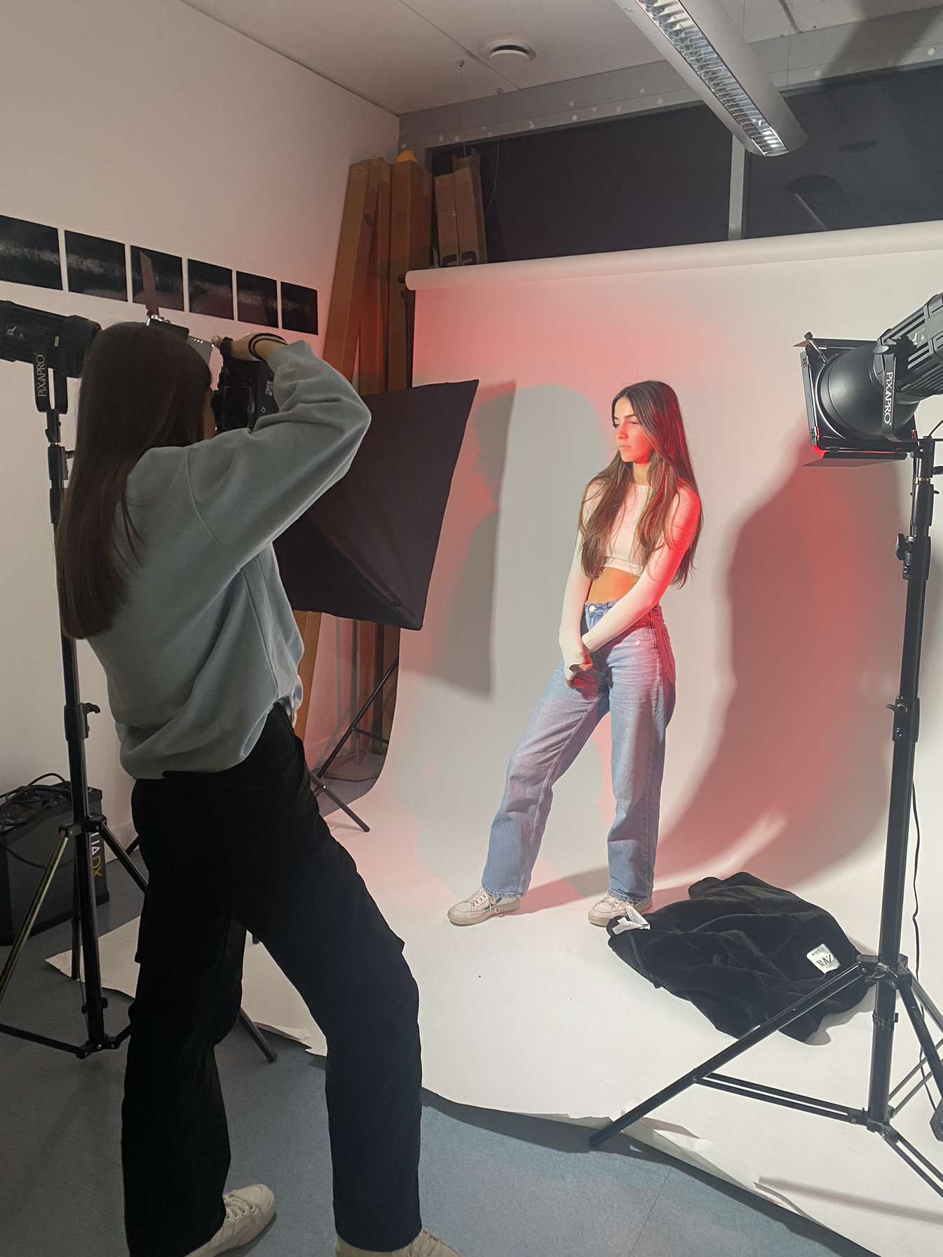Photographer working with a model under warm red wash