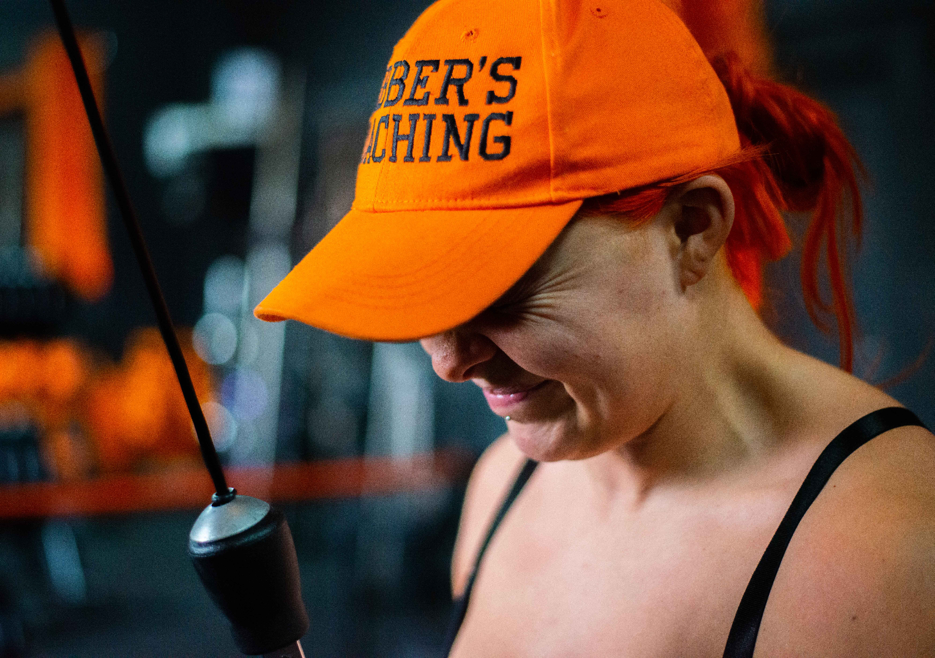 Athlete focused under orange cap, gym interior